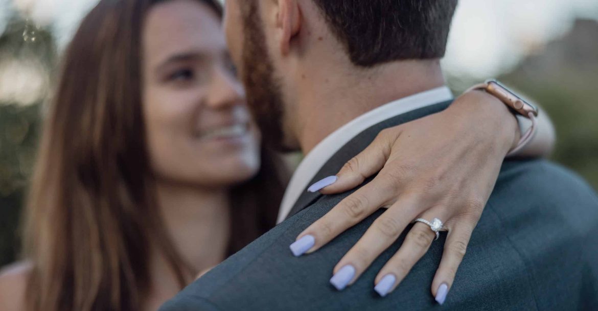 A bride and groom hugging each other during their engagement session.