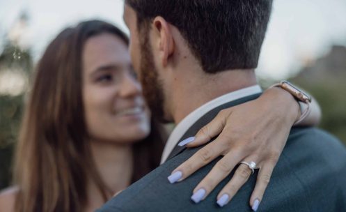 A bride and groom hugging each other during their engagement session.